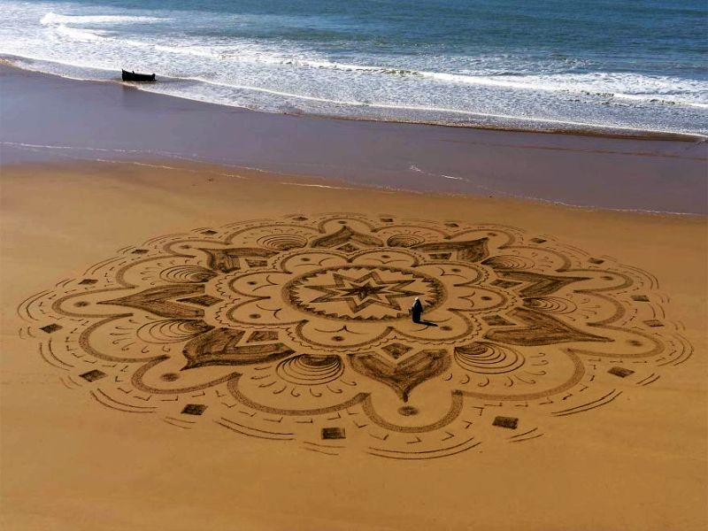 Artist creates huge mandalas on beach inspired by Arabic designs